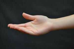 A person holding out their hand with a black background photo