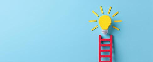 The light bulb atop a colorful ladder symbolizes creative innovation and inspiration. photo