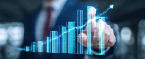 The businessman pointing at a growing digital graph representing financial success. photo