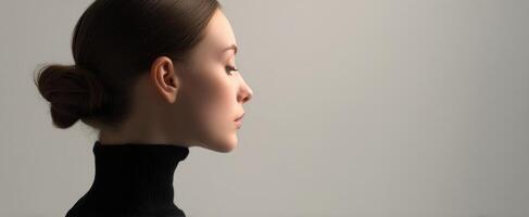 The elegant profile of a woman in a minimalist studio setting. photo