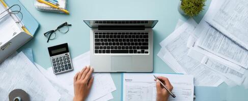 The laptop and documents on a modern office workspace for financial planning. photo