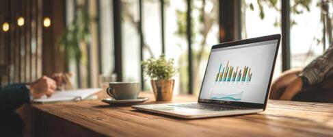 The laptop displaying statistical graphs in a cozy cafe workspace. photo