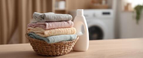 The colorful stack of towels beside a bottle of laundry detergent. photo