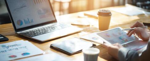 The laptop and tablet on a stylish workspace with charts and coffee. photo