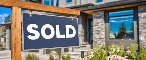 The sold sign in front of a beautiful modern family home. photo