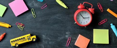 The vibrant arrangement of stationery and an alarm clock on a desk. photo