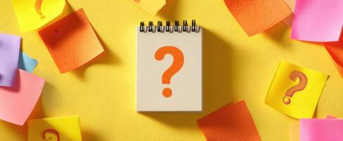 The notebook with a question mark surrounded by colorful sticky notes. photo