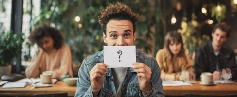 The young man holding a question card in a modern cafe setting. photo