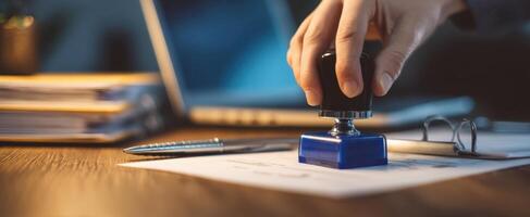 The hand applying a stamp on important business documents for approval. photo