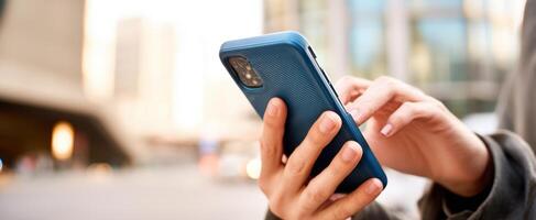 The smartphone in hands, showcasing modern connectivity in an urban environment. photo