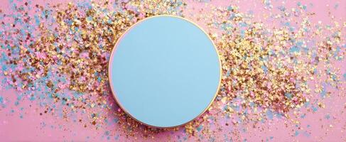 The round blue surface surrounded by colorful glitter sparkles on pink backdrop. photo