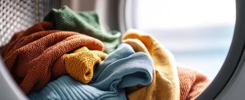 The vibrant towels and clothes freshly dried in a washing machine. photo
