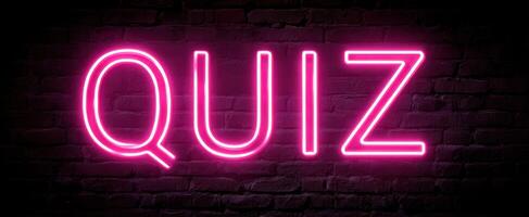The Neon Quiz Sign against a Dark Brick Background. photo