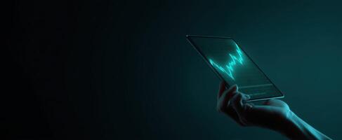 The futuristic tablet displaying a glowing waveform in a dark setting. photo