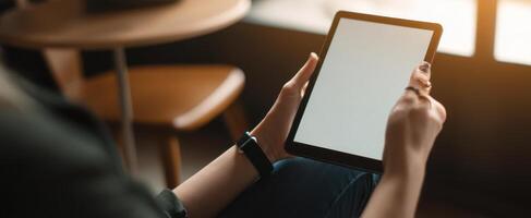 The person holding a tablet in a cozy, modern workspace setting. photo