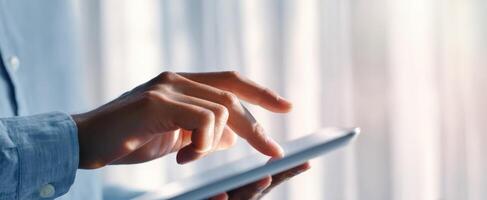The person interacting with a tablet in a modern workspace setting. photo