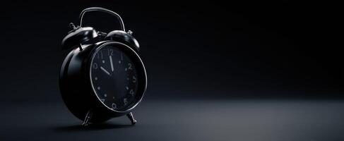 The classic black alarm clock with a sleek, modern design against a dark background. photo