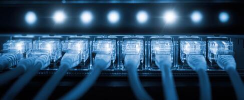 The Ethernet cables connected to a modern networking device glowing in blue light. photo