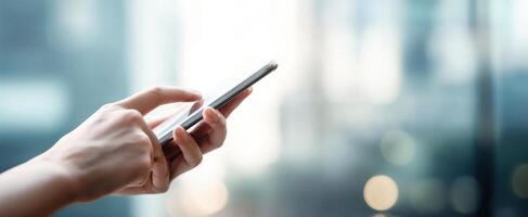 The hand interacting with a smartphone in a modern urban environment. photo