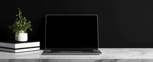 The sleek laptop positioned elegantly on a minimalist desk with a plant. photo