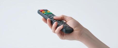 The hand holding a remote control for modern technology and entertainment. photo