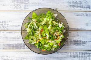 Fresh green microgreen salad on a light blue plate. A natural and organic concept for healthy eating and spring or summer food presentations. photo