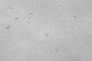 Rain drops on a window create a natural texture. Transparent liquid element for background or overlay effect concept on a gray surface. photo