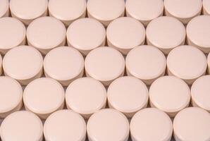 Rows of creamy color tablets close up photo
