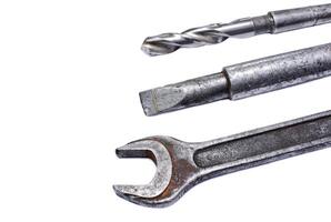 Shabby spanner, chisel and drill on white background photo