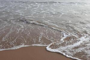 Beautiful waves on the sand beach in the morning photo