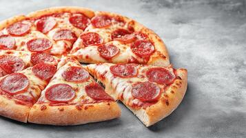 Pepperoni pizza with juicy melted cheese and a cut slice, set against a gray background photo