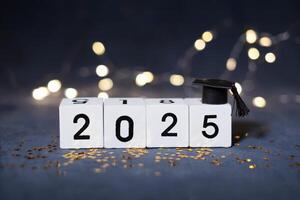 Class of 2025 concept. Wooden cubes with number 2025 with graduate hat photo