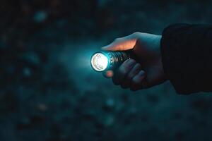 dramatic shot of hand holding glowing flashlight, symbolizing quest for truth in dark or hidden situations. concept searching, detective work, crime investigation in suspenseful narratives photo