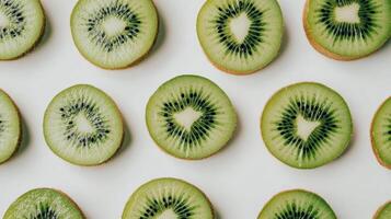 Vibrant kiwi slices forming geometric pattern against crisp white surface, highlighting fresh fruit symmetry and clean nutritional design elements photo