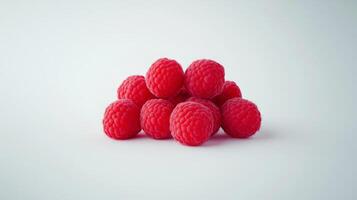 Ripe raspberries stacked pyramidal on pristine white surface, showcasing glossy red berries' vivid color and detailed natural texture photo