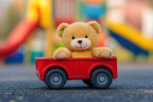 Cozy scene with stuffed bear sitting in toy truck placed on playground path, sunny daylight enhancing cheerful atmosphere photo