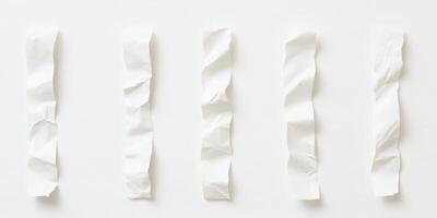 Five crumpled white paper strips on white background photo