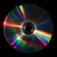Compact disc reflecting rainbow light interference patterns on black background photo