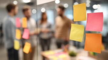 Business people discussing ideas with sticky notes on glass wall in office photo