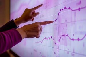 Teamwork, cooperation, and smooth workflow. Hands pointing at a digital graph on a screen. photo