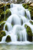 Tranquil waterfall cascading over mossy rocks. Pure water unpolluted concept. photo