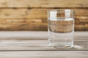 Clear glass of water on a wooden surface background. Pure water unpolluted concept. photo