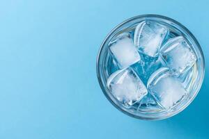 Bowl of ice cubes on a light blue background. Pure water unpolluted concept. photo
