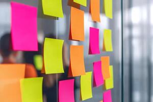Colorful sticky notes on a glass wall in an office setting. photo
