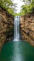 Waterfall cascading into a serene pool surrounded by rocky cliffs. photo
