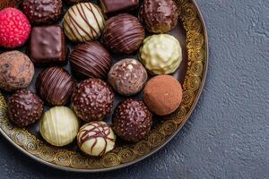 Delicious assorted chocolates on an ornate plate. photo