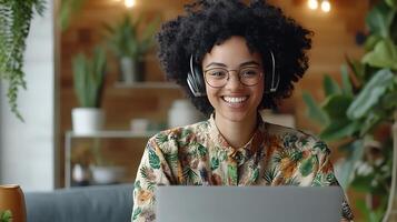remote worker smiling while on call, open laptop, headphones and tidy background photo