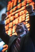 a dramatic image of trader cheering in front of rising market screen photo