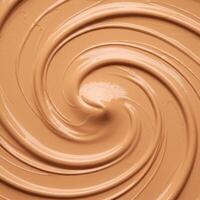 A close up view of liquid foundation swirling in circular patterns creating a textured look. photo