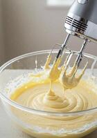 Hand mixer in a glass bowl, creating a smooth and delicious batter for baking. photo